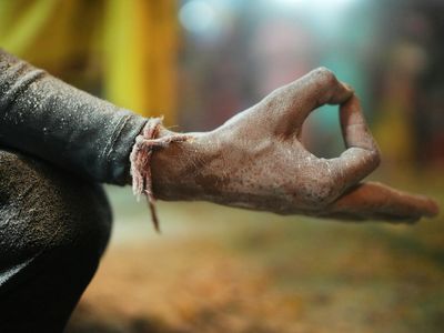 Close-up on hands in a specific yoga mudra, symbolizing focus.